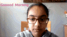 a girl with glasses is looking at the camera with the words goooood morning above her