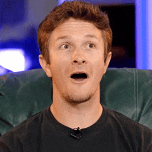 a man with a surprised look on his face wears a black shirt