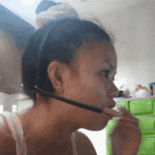 a woman is wearing a headset and eating a piece of food