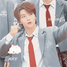 a man in a suit and tie is holding a piece of cake