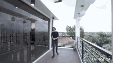 a man is standing on a balcony with the words made in animotica on the bottom