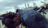 a man in a denim jacket is kneeling down in front of a mercedes sign