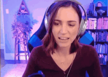 a woman wearing headphones and a necklace is sitting in a chair .