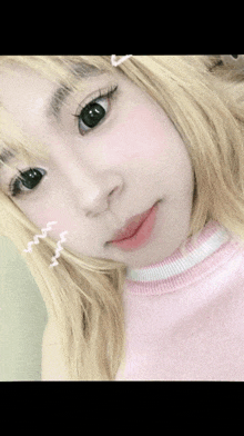 a girl with blonde hair and black eyes is wearing a pink shirt