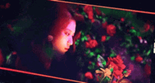 a woman is sitting in front of a bunch of roses