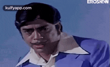 a man in a blue suit and white shirt is making a face .