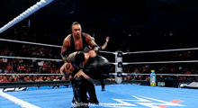 two men are wrestling in a ring with the words main stre top wrestling on the bottom right