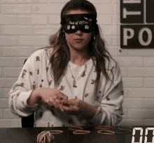 a woman is wearing a blindfold that says out of office