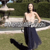 a woman is standing in front of a fountain with #mentalitefoutchi written above her