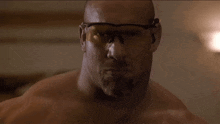 a man without a shirt is wearing safety goggles