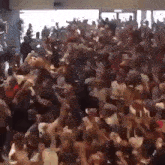 a large crowd of people are dancing in a room at a party .