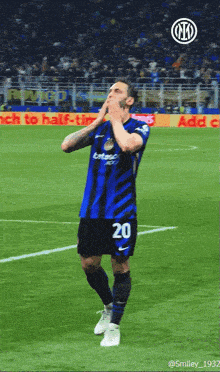 a soccer player with the number 20 on his jersey stands on the field