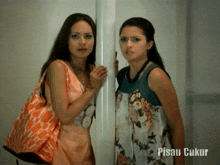 two women standing next to each other with the words pisau ukur on the bottom