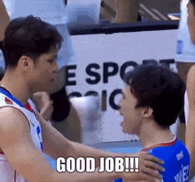 two basketball players are hugging each other in front of a sign that says " good job !!! "