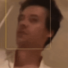 a close up of a person 's face with a yellow frame around it .