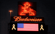a budweiser billboard with an american flag and a yellow ribbon