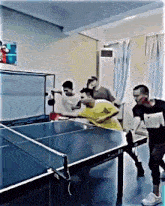 a group of people playing ping pong in a room