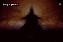 a silhouette of a person in a dark room with a sword in their hand .
