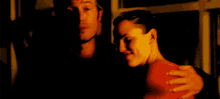 a blurry photo of a man and a woman with the woman 's arm around the man 's neck