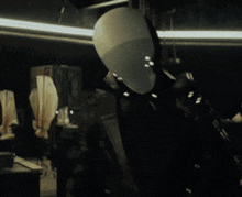 a mannequin in a dark room with a light behind it