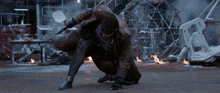a man in a trench coat is kneeling down and holding a sword
