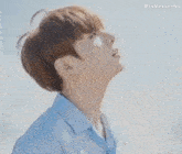 a close up of a young man looking up at the sky .