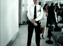 a man in a suit and tie stands in a hallway