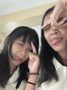 two girls make a peace sign with their hands