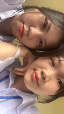 two girls are posing for a picture together and one has a bracelet on her wrist