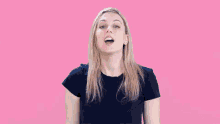 a woman in a blue shirt is making a surprised face .
