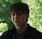 a close up of a young man 's face with a sad look on his face