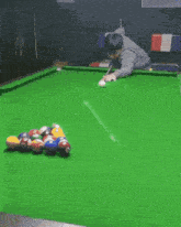 a man is playing pool on a green table with balls