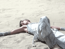 a woman in a white outfit is laying in the sand with the words & team written above her