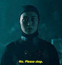 a woman wearing a head scarf says no please stop in a dark room