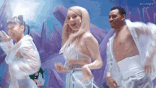 a group of people are dancing in front of purple crystals and the caption dovehdgifs