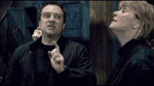 a man and a woman are standing next to each other in a dark room .