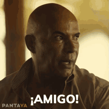 a man in a tan shirt says amigo on the bottom