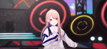 a girl in a white jacket is standing in front of a stage with a lot of lights on it .
