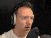 a man wearing headphones is singing into a microphone