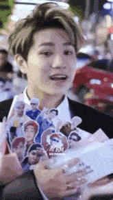 a man in a suit is holding a bouquet of flowers and stickers of himself .
