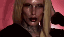 a close up of a woman 's face with a red background and a black shirt .