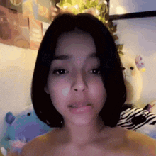 a woman without a shirt is making a funny face