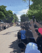 a man wearing a blue shirt with the number 10 on it stands in front of a crowd