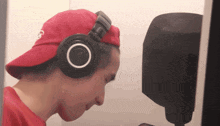 a man wearing a red hat and black headphones with a white circle in the middle