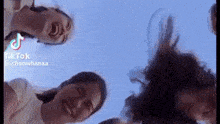 a group of people are standing in a circle with their heads together and smiling .