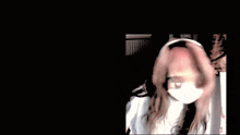a blurry picture of a woman wearing headphones and a face mask