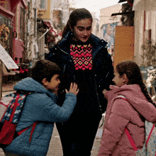 a girl in a pink jacket talks to a boy