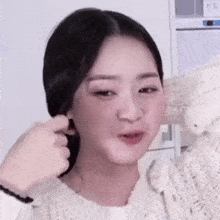 a woman in a white sweater is being piggybacked by another woman .