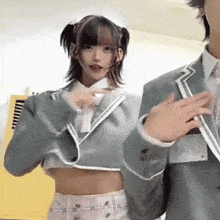 a woman in a crop top and a man in a suit are dancing together .