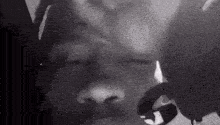 a black and white photo of a man 's face with a bird flying over it .